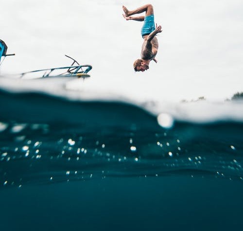 man jumping off a boat