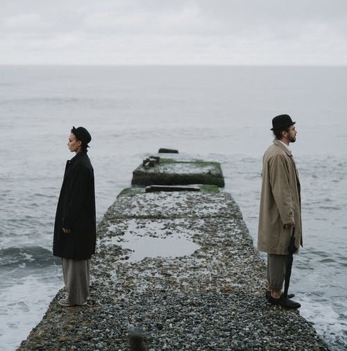 couple with backs turned on a rock path at sea