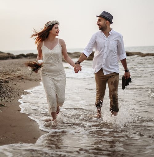 happy couple walking on seaside